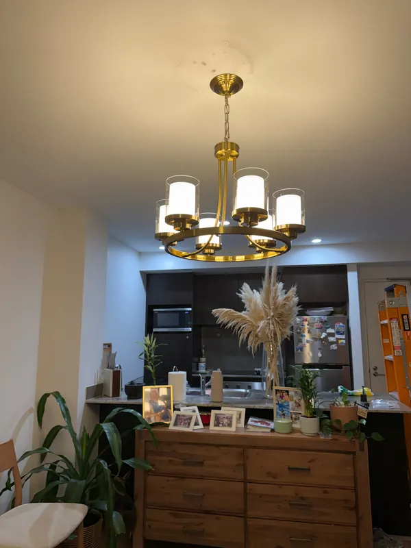 Brass six-light chandelier over a dining table in a Perth apartment, installed by OWCA Electrical